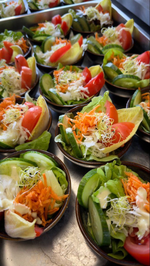 Een rij verse salades in de keuken.
